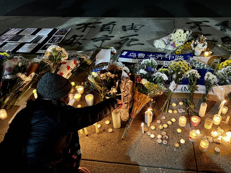 中国総領事館の向かい側の歩道に置かれた追悼の花束やロウソク=米ニューヨークで2022年11月29日、隅俊之撮影