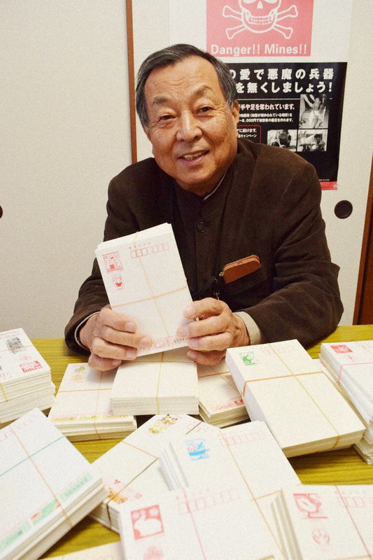 寄せられたはがきを手に「地雷撤去のためぜひ送ってほしい」と呼びかけるCMCの大谷理事長=福岡市早良区のCMC本部で2022年11月26日午後1時23分、吉川雄策撮影