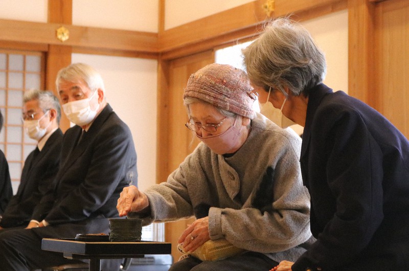 焼香をして免田さんをしのぶ妻玉枝さん(右から2人目)=福岡県大牟田市一部町の真宗木辺派行信寺で2022年12月4日午後0時半ごろ、降旗英峰撮影