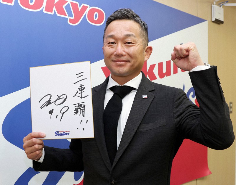 契約更改を終え、「三連覇」の色紙を手に記者会見したヤクルト・石川雅規=東京都港区のヤクルト球団事務所で2022年12月5日(代表撮影)