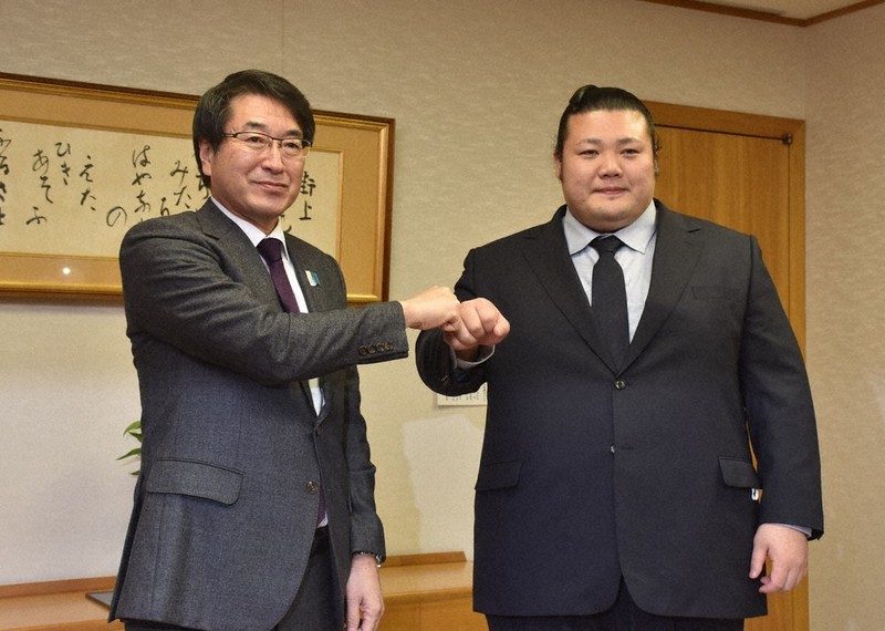 中原八一市長(左)とグータッチする元豊山関=新潟市中央区の新潟市役所で2022年12月6日、露木陽介撮影
