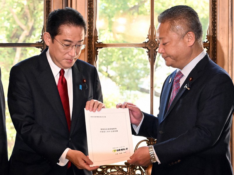 日本維新の会の馬場伸幸代表(右)から国家安全保障戦略などの改定に対する提言書を受け取る岸田文雄首相=国会内で2022年12月7日午後0時42分、竹内幹撮影