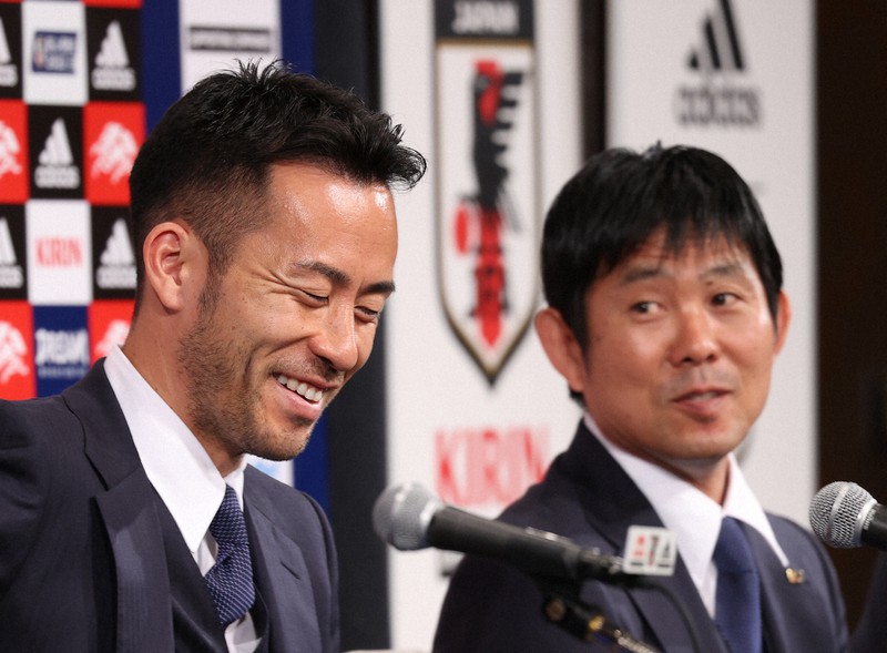 サッカーW杯カタール大会を終えて帰国し、記者会見で笑顔の日本代表の吉田麻也主将(手前)。奥は森保一監督=千葉県成田市で2022年12月7日午後8時1分、三浦研吾撮影
