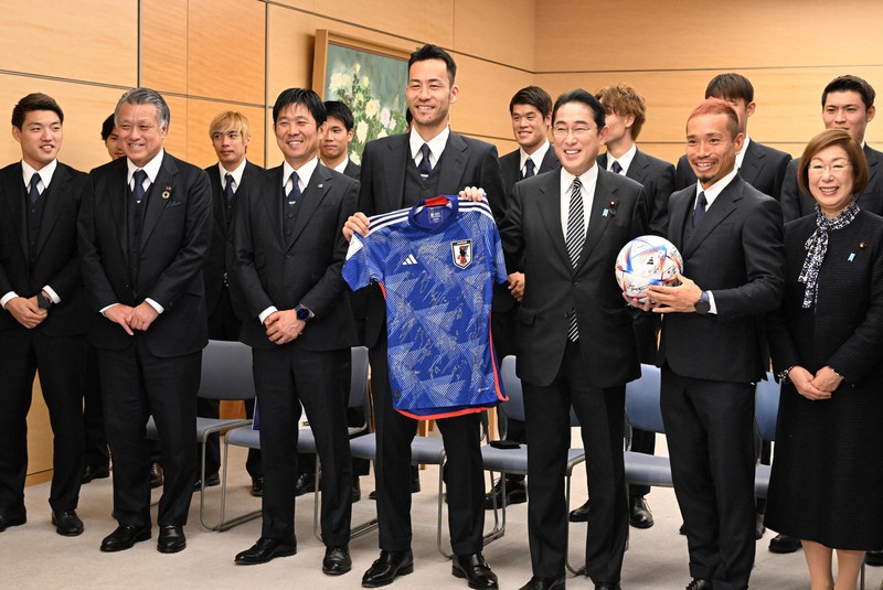 サッカー日本代表の吉田麻也選手(前列右から4人目)からユニホームをプレゼントされる岸田文雄首相(同3人目)。同5人目は森保一監督=首相官邸で2022年12月8日午後0時36分、竹内幹撮影