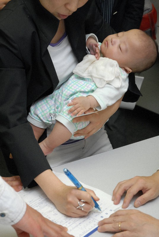 離婚後の妊娠が証明できれば前夫の子でない出生届を認める通達が出された当時、出生届を出す川村美奈さん=東京都内の区役所で2007年5月21日、内藤絵美撮影