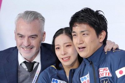 キス・アンド・クライで涙を流す三浦璃来（中央）と木原龍一（右）の肩に手をやり、笑顔を見せるブルーノ・マルコット・コーチ＝イタリア・トリノのパラベラ競技場で2022年12月9日、貝塚太一撮影