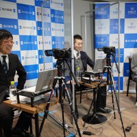 イベントで談笑する（左から）芳賀竜也デスク、倉沢仁志記者、貝塚太一カメラマン＝東京都港区で2022年12月27日、小林努撮影
