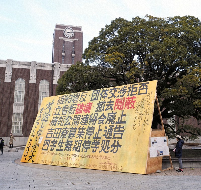 京都大時計台前の立て看板。大学改革が続くなか、こうした光景も影響力のある論文も減った=京都市左京区吉田本町の京都大で2016年12月24日午後2時半、鈴木英生撮影