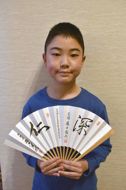 第72期王将戦七番勝負第2局の大盤解説会に参加した鍛治田将さん。手にしているのは記念の扇子