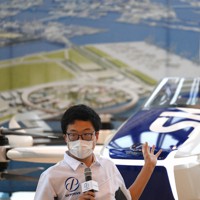 「空飛ぶクルマ」の説明をするスカイドライブ社の関係者＝大阪市住之江区で2021年9月14日午後3時29分、久保玲撮影