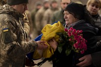Tetiana Hurieieva, the mother of Volodymyr Hurieiev, a Ukrainian soldier killed in the Bakhmut area, receives the flag that draped his coffin, during the funeral in Boryspil, Ukraine, on March 4, 2023.(AP Photo/Vadim Ghirda)
