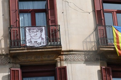 スペイン北東部バルセロナ旧市街地の建物に掲げられたカタルーニャ州独立派の旗（右）とプチデモン元州首相の似顔絵＝バルセロナで2023年2月21日午後1時半ごろ、岩佐淳士撮影