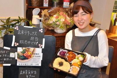 「玄米菜食弁当」を販売する大川柊葉さん＝神戸市中央区生田町2で、関谷徳撮影