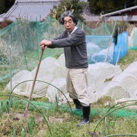自宅前の畑に立つ秋山豊寛さん＝三重県大台町で2023年3月16日、兵藤公治撮影