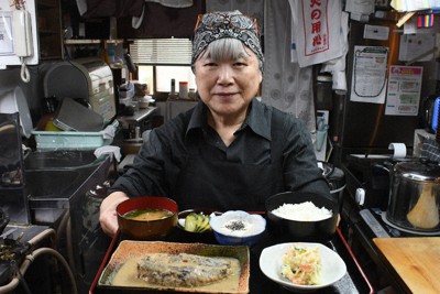 イワシのぬか炊き定食を持つ矢野さん