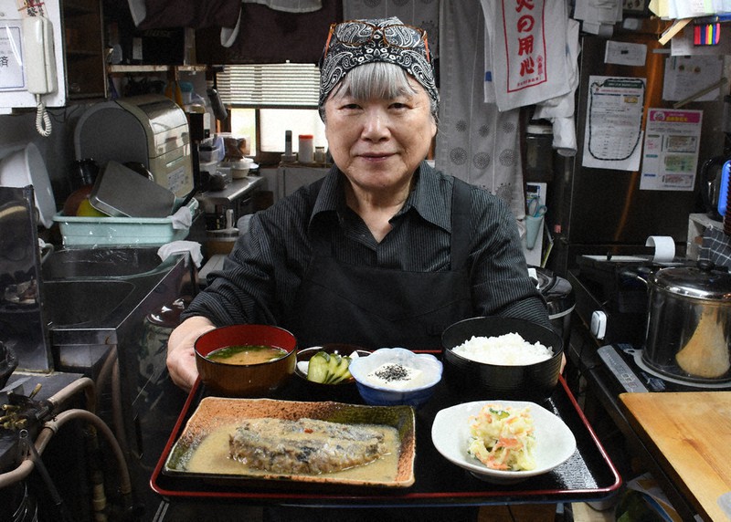 イワシのぬか炊き定食を持つ矢野さん