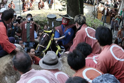 多度大社の上げ馬神事で、壁のような坂を懸命に駆け上がろうとする馬と騎手＝三重県桑名市で2023年5月4日、兵藤公治撮影