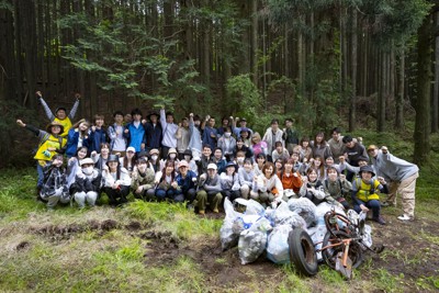 拳を突き出す野口教授（中央）を囲む参加者