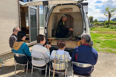 自作の茶室付きワゴン車で、地域住民にお茶をふるまう長谷川さん（中央）