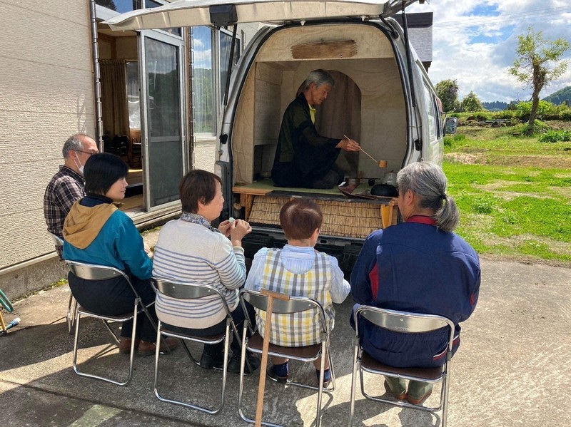 自作の茶室付きワゴン車で、地域住民にお茶をふるまう長谷川さん（中央）
