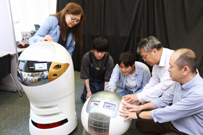 「漫才ロボット」のツッコミ役のあいちゃん（左）とボケ役のゴン太を起動させる甲南大の学生と教授ら＝神戸市東灘区で2023年6月7日、梅田麻衣子撮影