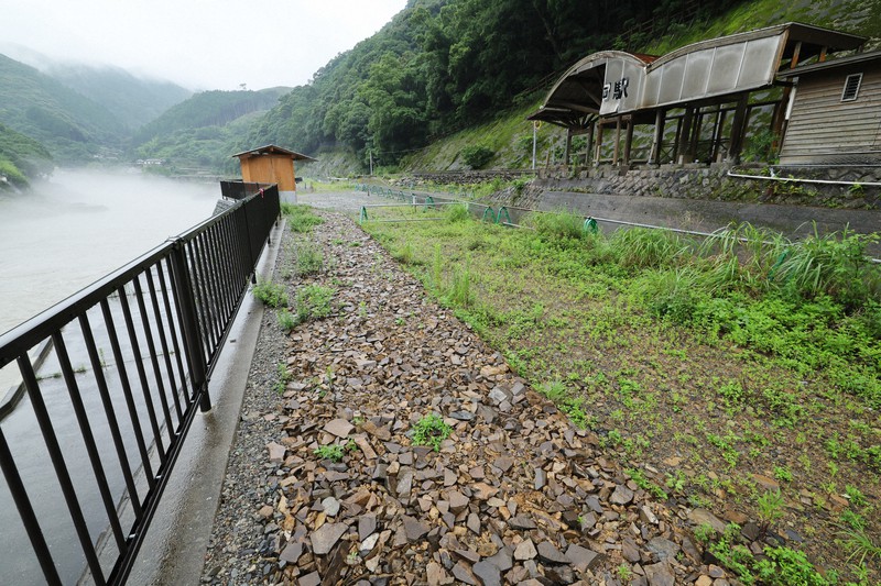 豪雨前、球磨川沿いのJR球泉洞駅前には川口商店と愛甲商店が軒を並べにぎわっていた。この2軒で5人が犠牲になり、更地となっている。川口商店跡地には祭壇が作られ、花が手向けられていた＝熊本県球磨村で2023年7月4日午後5時23分、吉田航太撮影