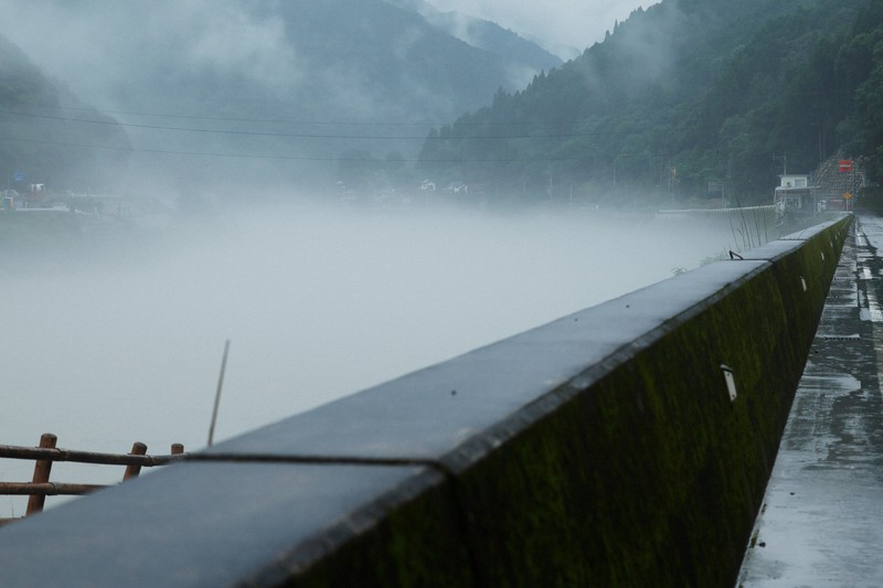 左奥の球磨川にかつてかかっていた神瀬橋は、豪雨により橋桁が全て流失し、橋脚の一部も倒れた。今は跡形もない＝熊本県球磨村で2023年7月4日午後5時4分、吉田航太撮影
