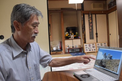 写真を見ながら、当時を振り返る丹羽隆文さん。奥の仏壇には、玲子さんが好きだったアップルパイを供えている＝岐阜県各務原市で2023年7月19日午後3時16分、酒井志帆撮影