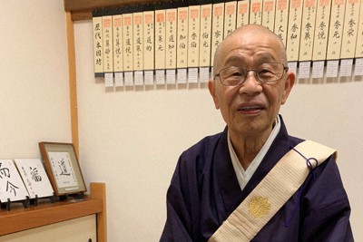 寂光寺の本堂で初代本因坊算砂について話す大川定信住職。壁には歴代本因坊の名札が掲げられていた＝京都市左京区で2023年7月15日、最上聡撮影
