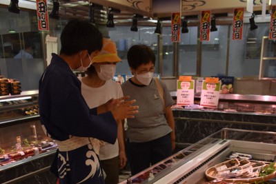 学校で養殖したウナギの特徴などを買い物客に説明する焼津水産高校の生徒（左端）＝静岡市葵区の松坂屋静岡店で2023年7月26日午前11時39分、丹野恒一撮影