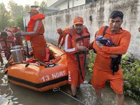 In this photo made available by the National Disaster Response Force (NDRF) on Aug. 15, 2023, an NDRF personnel carries an infant to safety in flood-affected Himachal Pradesh state, India. (National Disaster Response Force via AP)