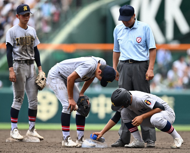 慶応の一塁コーチャーが仙台育英の選手に冷却スプレー 夏の甲子園