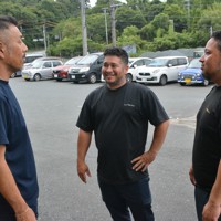 ブラジル人ドライバーたちとやり取りするマルシンレッカー運輸の日本人社員（左）。なるべく平易な日本語を使い、意思疎通を図っているという＝静岡県磐田市で2023年7月14日、金志尚撮影