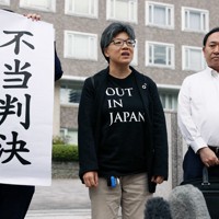 判決を受けて「不当判決」と書かれた紙を掲げる弁護士の隣で心情を語る原告の佐々木カヲルさん（中央）＝札幌市中央区で2023年9月11日午後2時1分、貝塚太一撮影