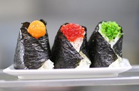 Onigiri from the "Bongo" specialty chain, characterized by its arrangement of fillings, is seen in Tokyo's Toshima Ward on Aug. 4, 2023. From left, the main ingredients are soy marinade, salmon roe and green "shiso" perilla leaves. (Mainichi/Ririko Maeda)