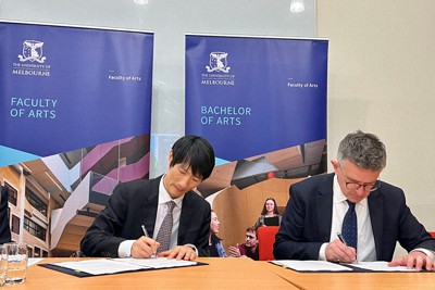 ゴールバーン教養学部長（右）と春名副学長による協定書への署名