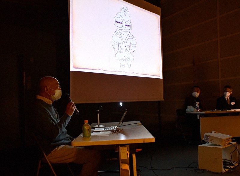 講演で、目覚めた時に現れた土偶の幻視についてイラストを紹介しながら振り返る三橋昭さん＝横浜市西区で2022年2月1日午後2時14分、銭場裕司撮影