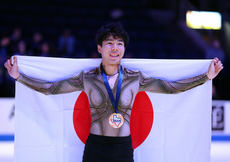 男子3位となり表彰式で日の丸を背に笑顔を見せる佐藤駿＝米アレンで2023年10月21日、猪飼健史撮影
