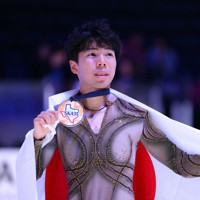男子3位となり表彰式で日の丸を背に記念撮影に応じる佐藤駿＝米アレンで2023年10月21日、猪飼健史撮影