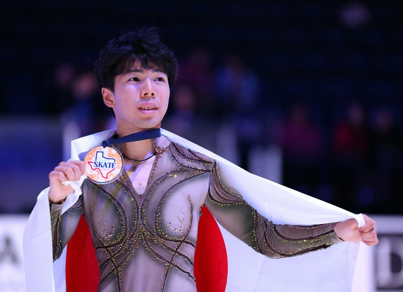 男子3位となり表彰式で日の丸を背に記念撮影に応じる佐藤駿＝米アレンで2023年10月21日、猪飼健史撮影