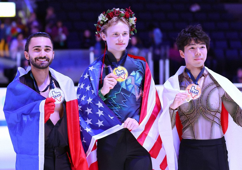 表彰式で記念撮影に応じる（左から）2位のケビン・エイモズ、1位のイリア・マリニン、3位の佐藤駿＝米アレンで2023年10月21日、猪飼健史撮影