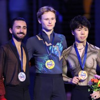 表彰式で記念撮影に応じる（左から）2位のケビン・エイモズ、1位のイリア・マリニン、3位の佐藤駿＝米アレンで2023年10月21日、猪飼健史撮影