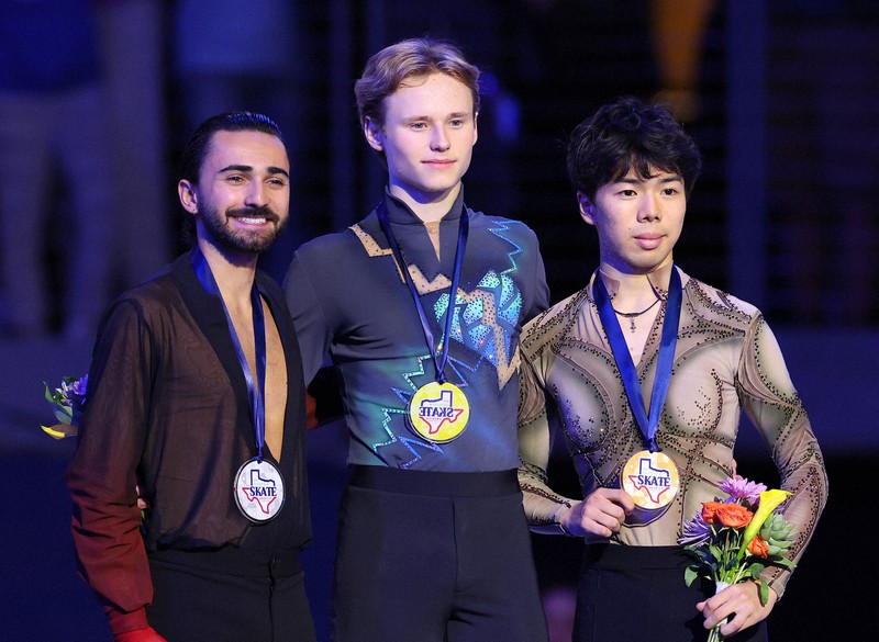 表彰式で記念撮影に応じる（左から）2位のケビン・エイモズ、1位のイリア・マリニン、3位の佐藤駿＝米アレンで2023年10月21日、猪飼健史撮影