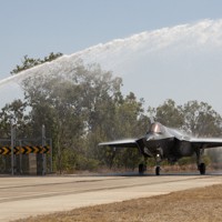 オーストラリア・ティンダル空軍基地に降り立ち、歓迎の放水を受ける航空自衛隊のF35A戦闘機＝2023年8月26日（防衛省提供）