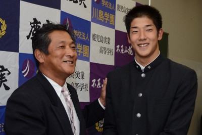 2013年のドラフト会議で阪神から指名され父親の真之さん（左）と握手する横田慎太郎さん。今年7月に脳腫瘍で亡くなった＝鹿児島市で2013年10月24日午後7時35分、土田暁彦撮影