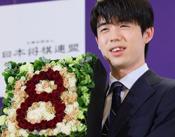記者会見でバラの花を使い数字の8をかたどったフラワーボックスを手に写真撮影に応じる8冠の藤井聡太名人＝名古屋市中村区で2023年10月13日、兵藤公治撮影