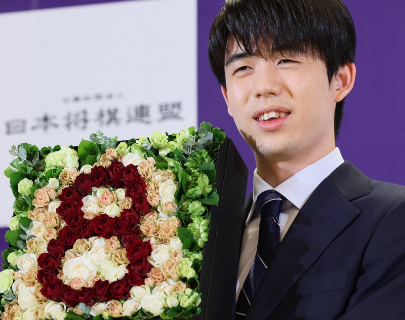 記者会見でバラの花を使い数字の8をかたどったフラワーボックスを手に写真撮影に応じる8冠の藤井聡太名人＝名古屋市中村区で2023年10月13日、兵藤公治撮影
