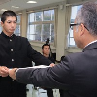 21世紀枠の県推薦校に選ばれ、県高野連の奥田宏会長（右手前）から表彰状を受け取る田口悠翔主将＝別府市野口原で