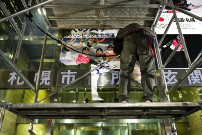 札幌市役所北玄関からはがされていく札幌冬季五輪招致ポスター＝札幌市中央区で2023年11月15日午後6時、貝塚太一撮影