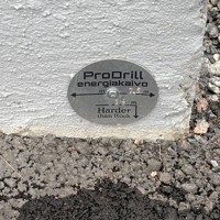 マンション外壁の地面近くに取り付けられたプレート。地中熱を暖房に利用するためのパイプを埋めた場所を示している＝ヘルシンキで2023年9月20日、念佛明奈撮影